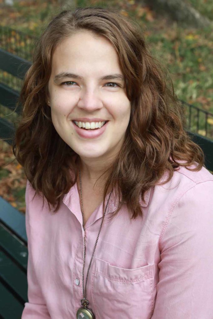 Abigail Shaw smiling seated on a bench outside