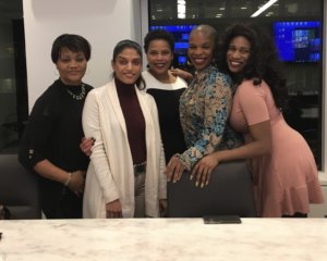 Five women of color with disabilities smile together