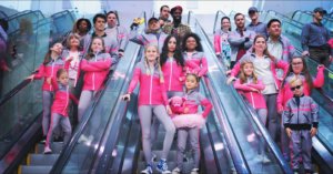 The cast of Feel The Beat on Netflix riding down three separate escalators