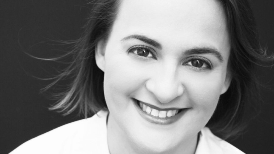 Elisabeth J Finch smiling black and white headshot. Elisabeth is a white woman with dark hair