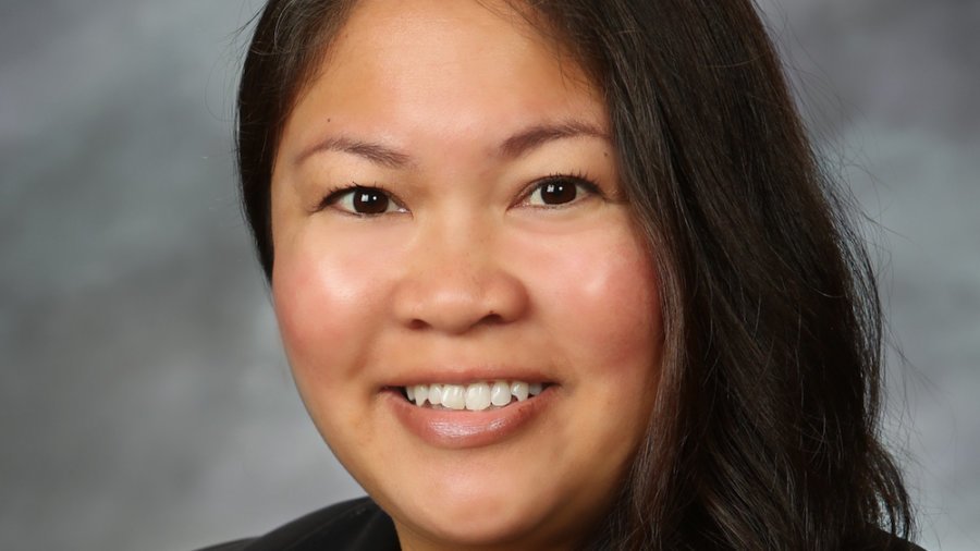 Stephanie Lomibao smiling headshot. Stephanie has long brown hair