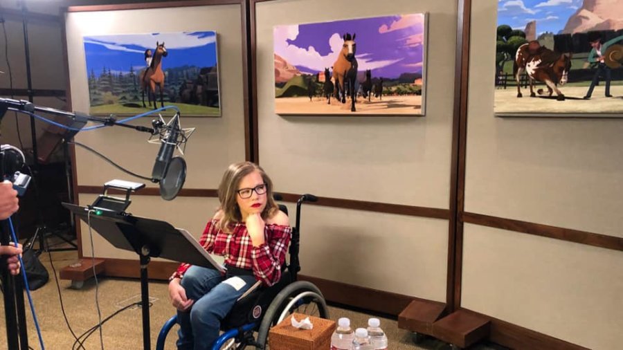 Cassidy Huff seated in her wheelchair in a recording studio
