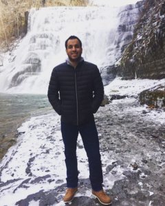 Franklin Anderson smiling, standing in front of a waterfall