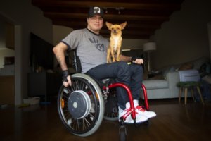 Roque Renteria with his dog on his lap. Roque is a wheelchair user.