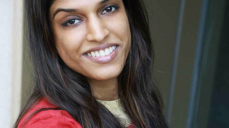 Headshot of Khadija Bari smiling leaning against a wall