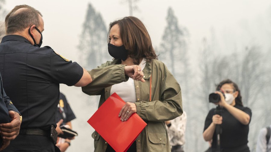 Kamala Harris bumps elbows with a firefighter in Auberry California. Nasreen Alkhateeb is in the background filming