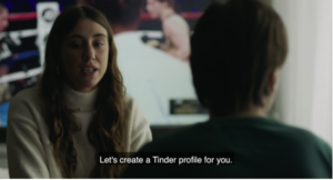 A scene from Alive with a woman speaking to another woman with a disability. Subtitle reads "Let's create a Tinder profile for you."
