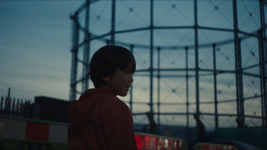 A young boy walking outside in a scene from The Reason I Jump