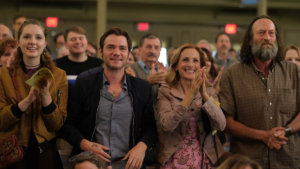 A still from CODA with actors in the movie standing and applauding