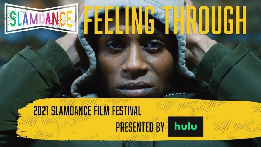 Robert Tarango with his hands on his head wearing a hat in a scene from Feeling Through. Slamdance logo. Text: 