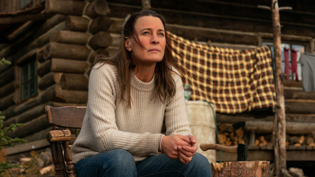 Robin Wright seated on a porch in a scene from Land