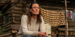 Robin Wright seated on a porch in a scene from Land