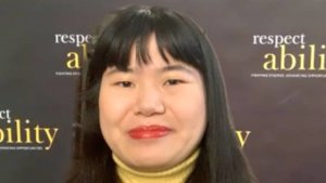 Ava Rigelhaupt smiling in front of a RespectAbility backdrop