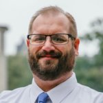 Wes Dotson headshot wearing glasses.