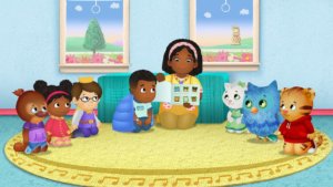 A scene from Daniel Tiger's Neighborhood with Max and all of the o there characters on a rug listening to a story