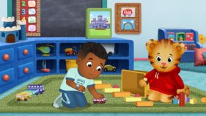 A scene from Daniel Tiger's Neighborhood with Max playing with toy cars