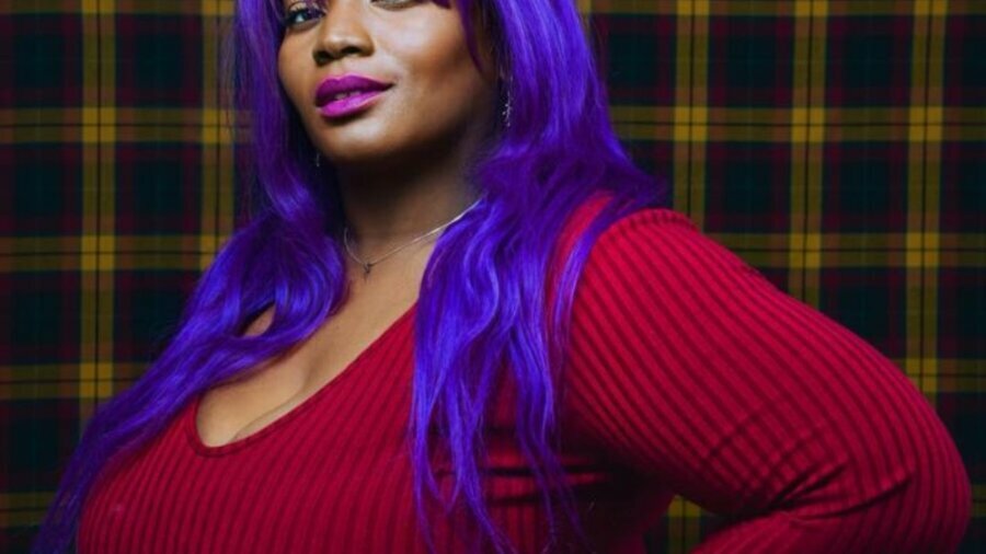 Asha Chai-Chang headshot with purple hair and wearing a red shirt