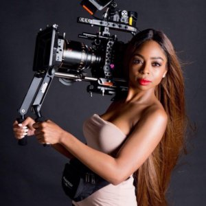 Kimisha Renee Davis headshot holding a large camera.