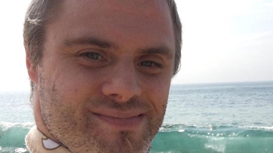 Shlomo Meyers smiling headshot on the beach with the ocean behind him