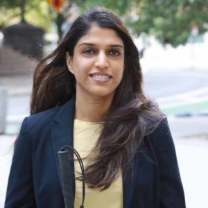 Khadija Bari smiling holding a white cane