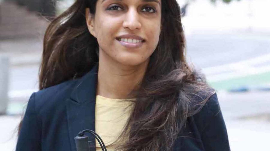 Khadija Bari smiling holding a white cane