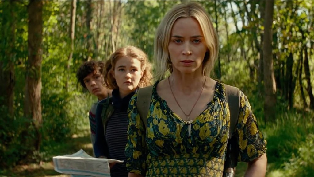 Noah Jupe, Millicent Simmonds, and Emily Blunt walking in the woods in A Quiet Place Part II.