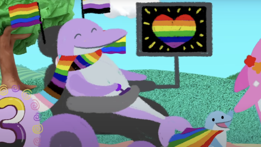 Still from the Blues Clues pride video with a purple dolphin in a wheelchair with a screen attached to it showing a rainbow heart