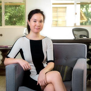 Naomi Funabashi headshot seated on a cushioned chair