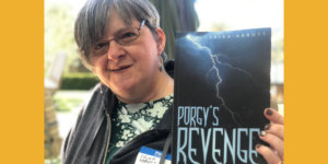 Erika Abbott smiling holding a copy of her book, Porgy's Revenge.