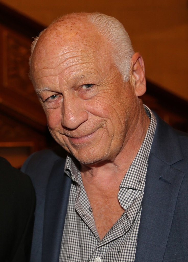 Joey Travolta smiling headshot wearing a suitjacket