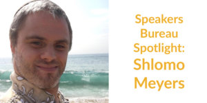 Shlomo Meyers smiling headshot on the beach with the ocean behind him. Text: Speakers Bureau Spotlight: Shlomo Meyers