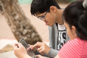 A student with a disability and a teacher use an iPad together