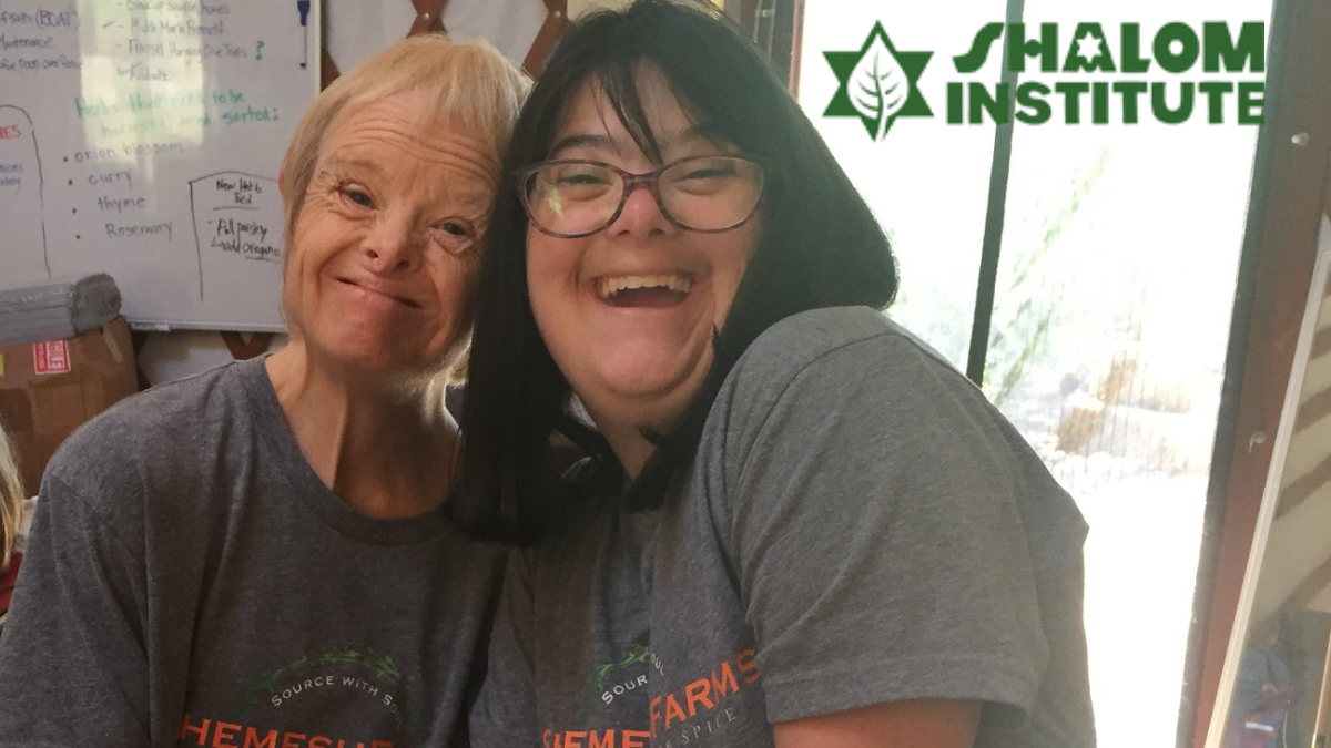 Two people with disabilities smiling wearing Shemesh Farm t-shirts. Shalom Institute logo.