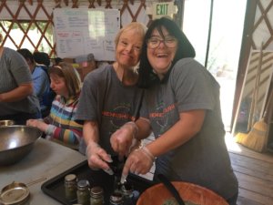 Two people with disabilities smiling wearing Shemesh Farm t-shirts