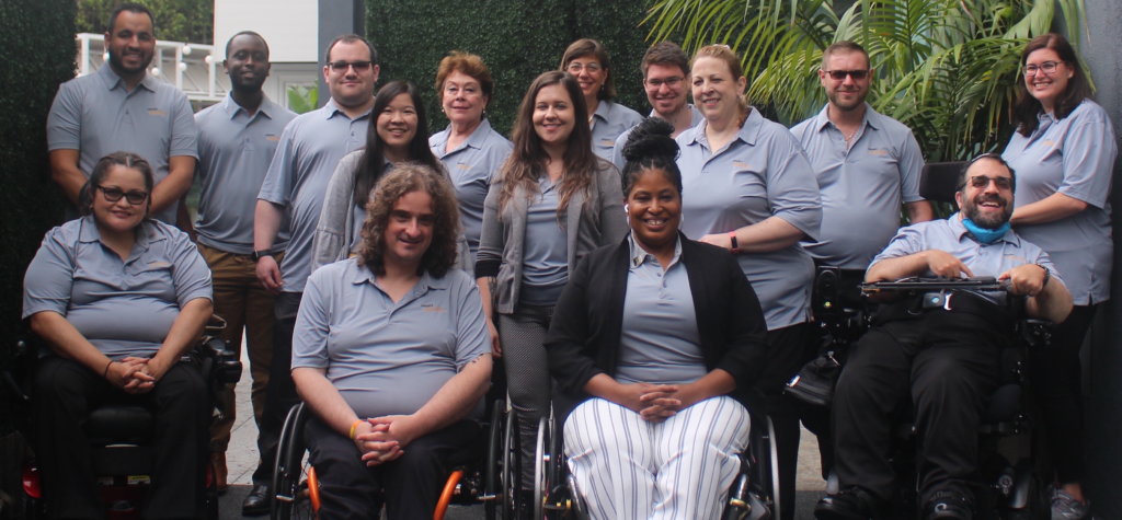 RespectAbility staff members smile together wearing gray polo shirts with the RespectAbility logo on them