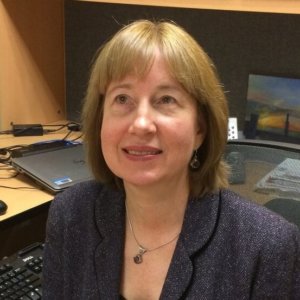 Carol Dobak headshot seated at her desk smiling