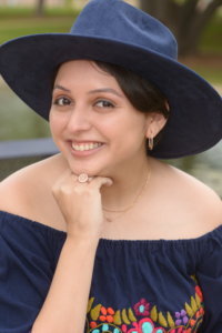 Alejandra Tristan smiling wearing a hat