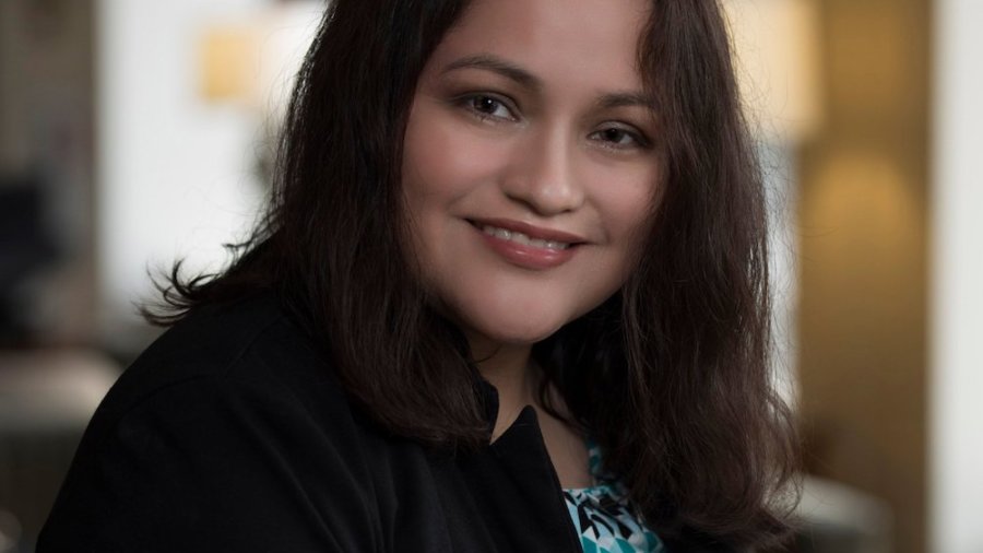 Nelly Nieblas smiling headshot. Nieblas has a disability in her right arm.