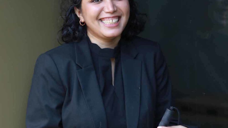 Baksha Ali holding a white cane, smiling