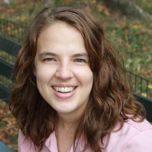 Abigail Shaw smiling seated on a bench outside