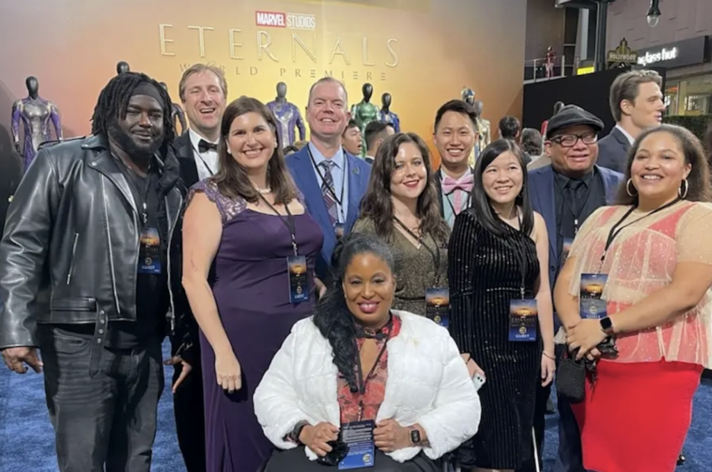 group of diverse disabled individuals in front of eternals sign