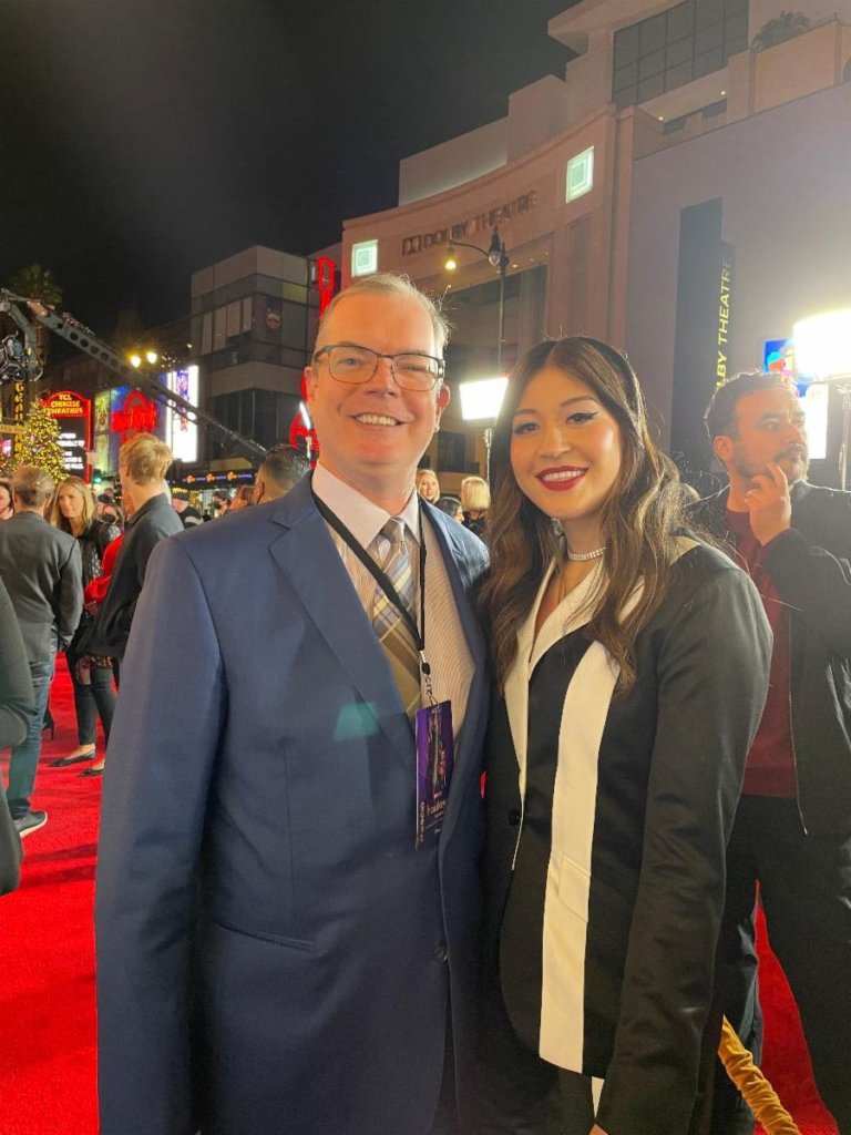 Delbert Whetter and Alaqua Cox smile together on the red carpet outside of the Dolby Theater