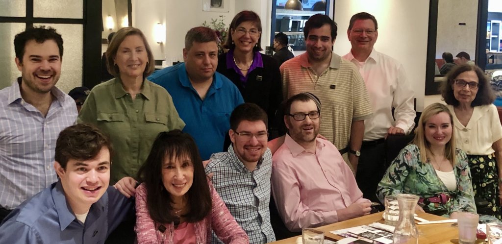 RespectAbility team members and allies smile together seated and standing behind a table