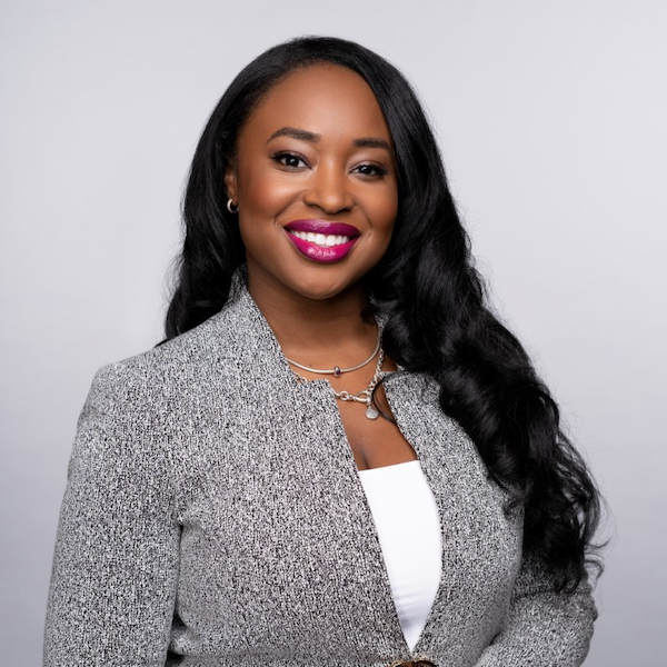 Courtney Munnings smiling headshot wearing a grey jacket over a white top.