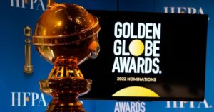 A golden globe statue next to a screen with the logo for Golden Globe Awards and text reading 2022 nominations