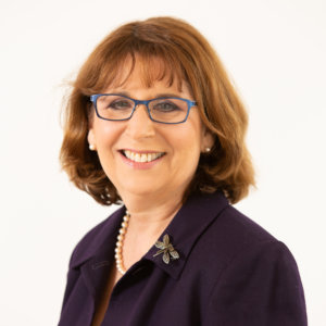 Dr. Deborah Fisher smiling headshot wearing glasses and a blazer