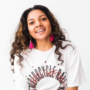 Ellynne Davis smiling wearing a white t-shirt and red earings