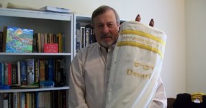 Rabbi Lenny Sarko holding the first ever Hebrew Braille Sefer Torah