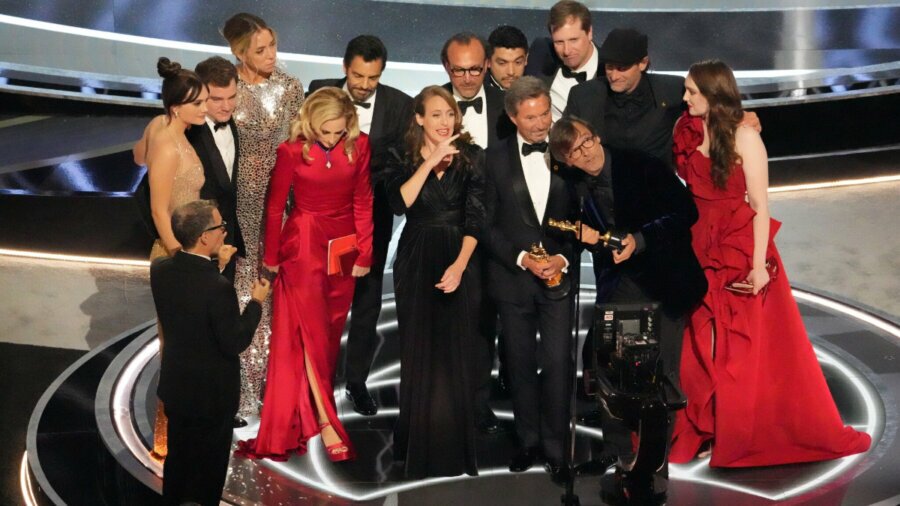The cast and crew of CODA on stage accepting the award for Best Picture