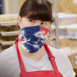 Collette Divitto in her bakery wearing a mask and apron in a scene from Born For Business